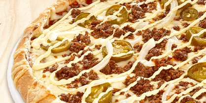 Pizza mit Hackfleischkrümeln, Jalapeños, Zwiebelstreifen und hellen Cremestreifen
