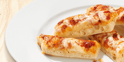 Drei überbackene Pizza-Sticks mit Tomatensauce und Käse auf einem weißen Teller. Im Hintergrund eine helle Holzoberfläche.
