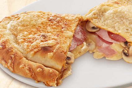 Pizza als Tasche, gefüllt mit Salami, Hinterschinken, frischen Champignons und mit Käse überbacken.