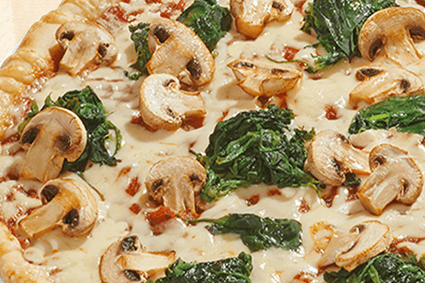 Pizza mit frischem Spinat und gebratenen Champignons auf heller Käsesauce