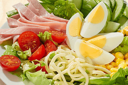 Eisberg- und Römersalat, Cherry-Tomaten, Gurke, Ei, Hinterschinken, Mais und Käse.