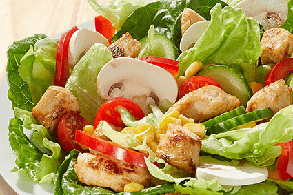 Eisberg- und Römersalat, Cherry-Tomaten, Gurke, frische Champignons, Paprika, Mais und gebratenes Hähnchenbrustfilet.