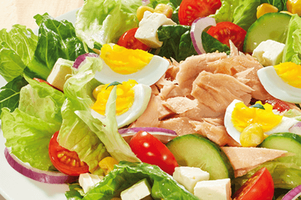 Thunfischsalat mit Blattsalat, Thunfisch, gekochtem Ei, Tomaten, Gurke, roten Zwiebeln, Mais und weißen Käsewürfeln.