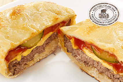 Burger im Smiley's Pizza-Teig, mit Cheddar-Cheese-Sauce, Jalapeños, roten Zwiebeln sowie Cheddar Schmelzkäse gefüllt und mit zartem Käse überbacken.