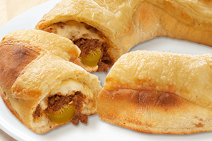 Pizza-Ring gefüllt mit Beef, Zwiebeln, Jalapeños, Käse, Sauce Hollandaise und mit Käse überbacken