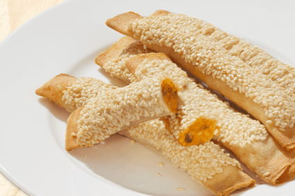 Thai Curry Sticks mit Sesam und cremiger Curryfüllung auf einem weißen Teller.