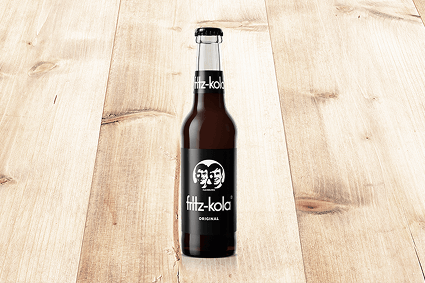 Fritz-Kola-Flasche vor neutralem Hintergrund.