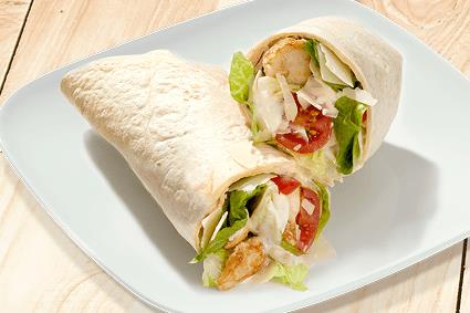 Halbierter Wrap mit Hähnchen, Tomaten und Salat auf weißem Teller